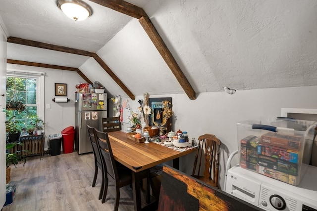 dining space with a textured ceiling, vaulted ceiling, radiator heating unit, and wood-type flooring