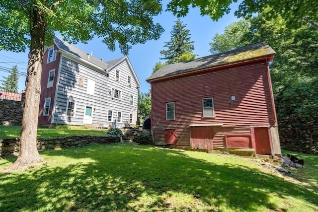 rear view of house featuring a lawn