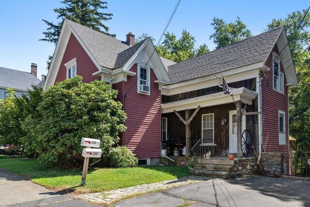 view of front of property with covered porch and a front lawn