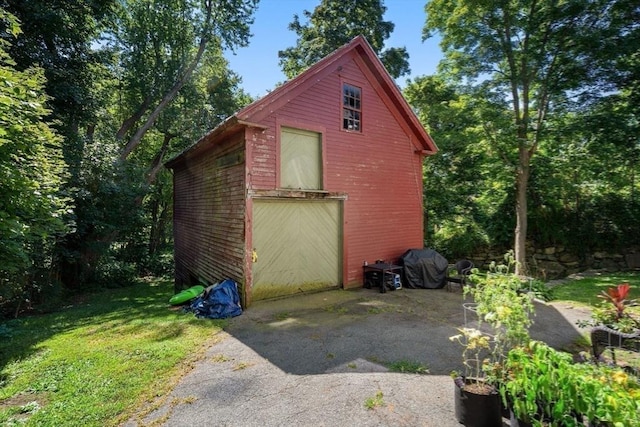 view of outdoor structure featuring a garage, aphalt driveway, and an outdoor structure