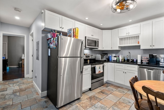 kitchen with white cabinetry, stainless steel appliances, and sink