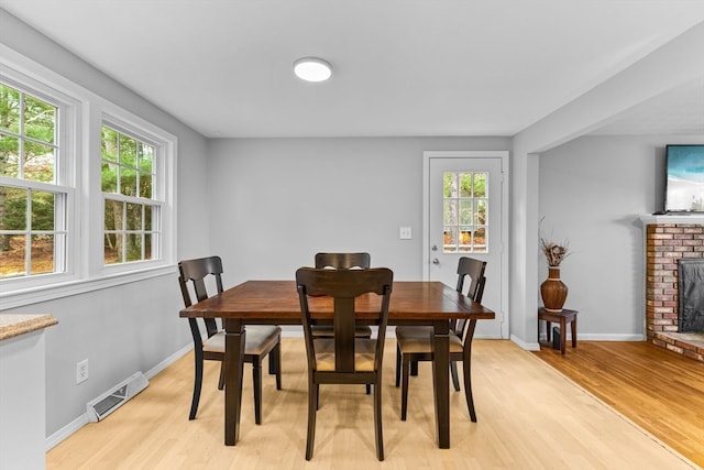 dining area with a fireplace and light hardwood / wood-style flooring