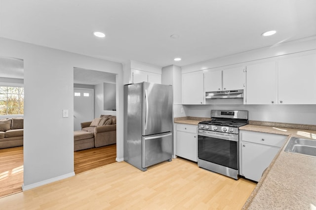 kitchen with white cabinets, light wood-type flooring, and stainless steel appliances