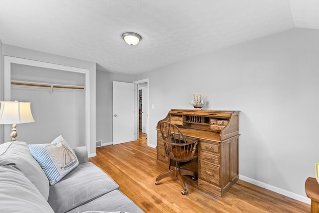 office area featuring hardwood / wood-style floors and lofted ceiling