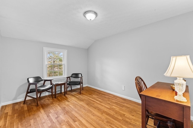 office space featuring vaulted ceiling and light hardwood / wood-style flooring