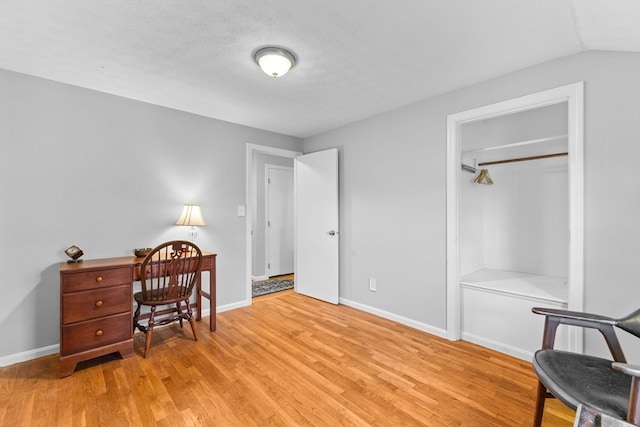 office space with a textured ceiling, light hardwood / wood-style flooring, and lofted ceiling