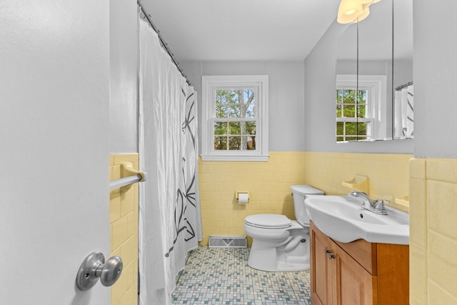 bathroom featuring tile patterned flooring, vanity, tile walls, and a wealth of natural light