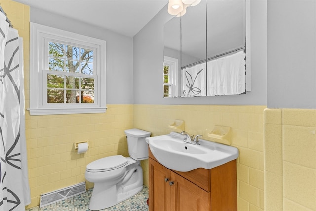 bathroom with tile patterned flooring, vanity, plenty of natural light, and tile walls