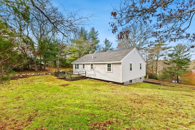 back of property with a deck and a lawn