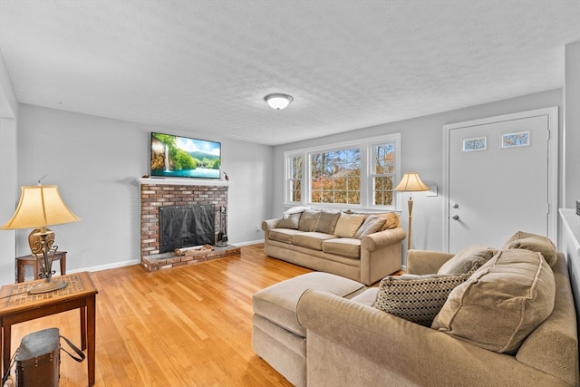 living room featuring hardwood / wood-style flooring, a textured ceiling, and a brick fireplace