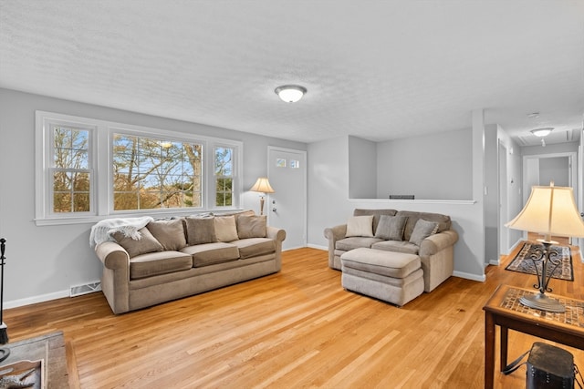 living room with a textured ceiling and light wood-type flooring