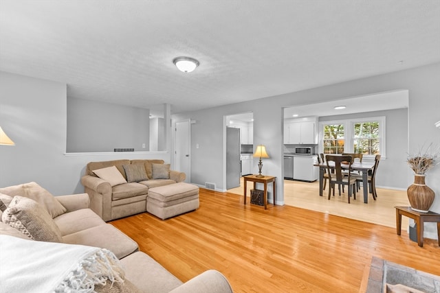 living room featuring a textured ceiling and light hardwood / wood-style flooring