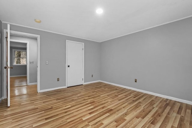 unfurnished bedroom with baseboards, crown molding, and light wood-style floors