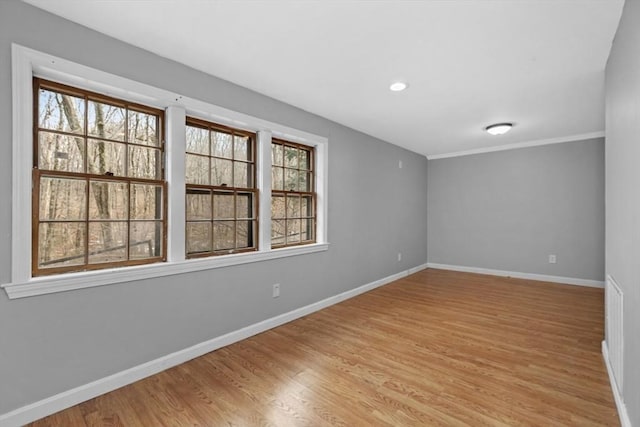 spare room with a wealth of natural light, baseboards, light wood-style flooring, and recessed lighting