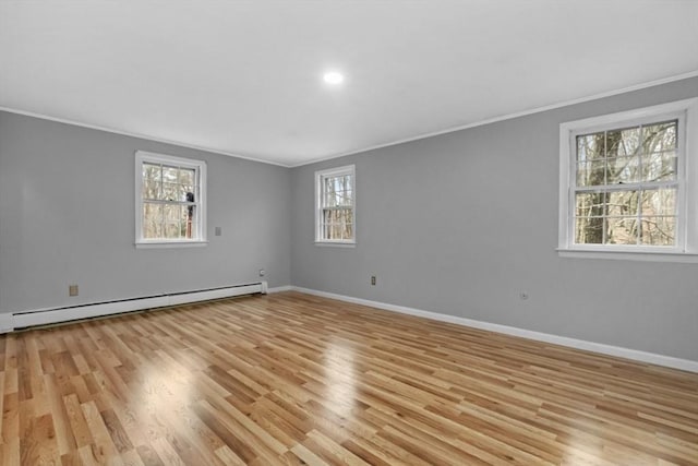 unfurnished room with ornamental molding, light wood-style floors, baseboards, and a baseboard radiator