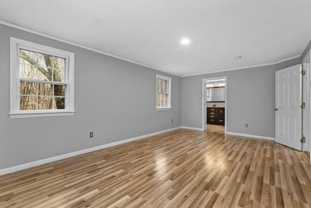 unfurnished bedroom with baseboards, light wood-style floors, ensuite bathroom, and crown molding