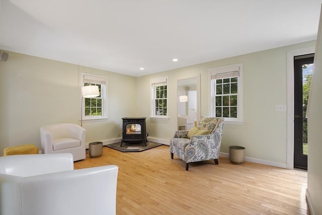 1230 Rte 149, Barnstable, MA 02648 - living area featuring a wood stove, light wood finished floors, baseboard heating, recessed lighting, and baseboards