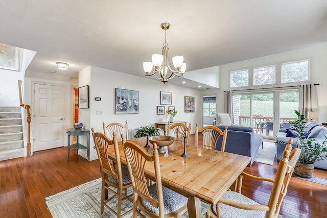 dining space with hardwood / wood-style flooring and a notable chandelier