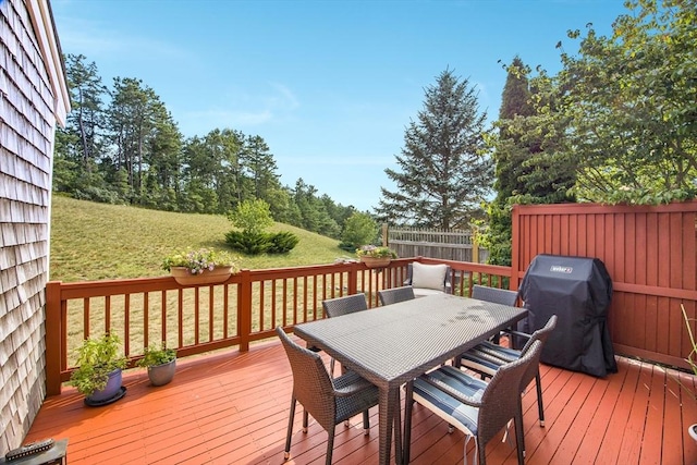 deck featuring a grill and a lawn