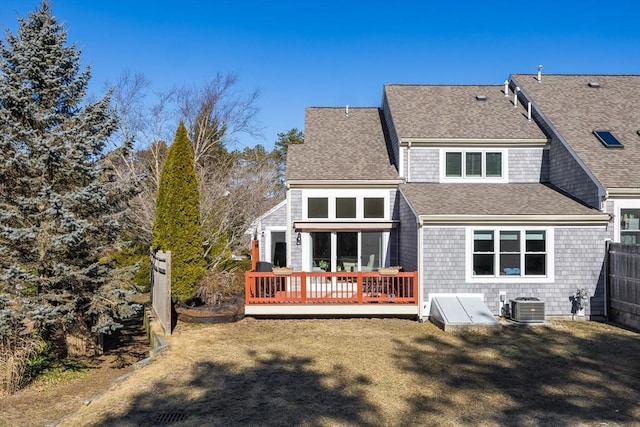 rear view of house featuring central AC unit, a lawn, and a deck