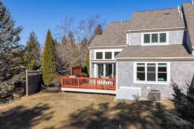 rear view of house featuring central AC, a deck, and a lawn