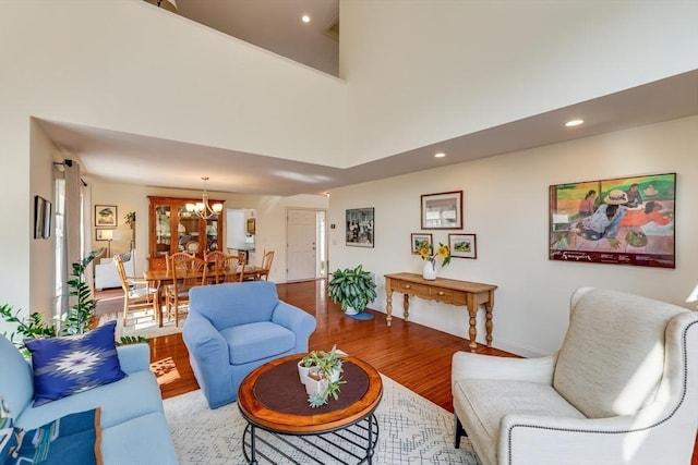 living room with hardwood / wood-style flooring, a high ceiling, and a notable chandelier