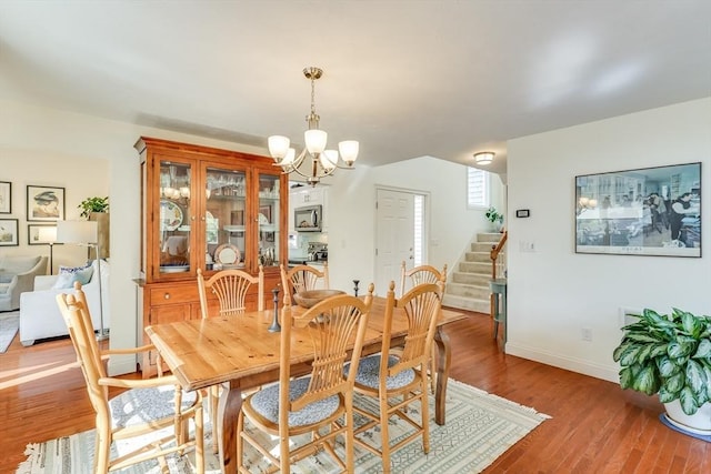 dining area with hardwood / wood-style floors and a notable chandelier