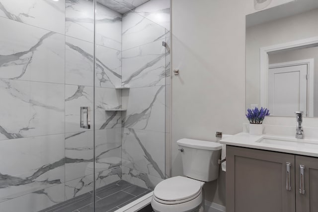 bathroom featuring vanity, toilet, and a shower with door