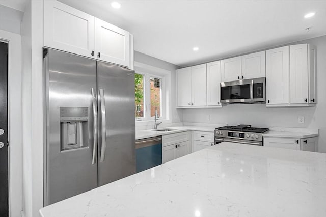 1514 Gorham St Unit 4, Lowell, MA 01852 - kitchen with appliances with stainless steel finishes, a sink, light stone countertops, white cabinets, and recessed lighting