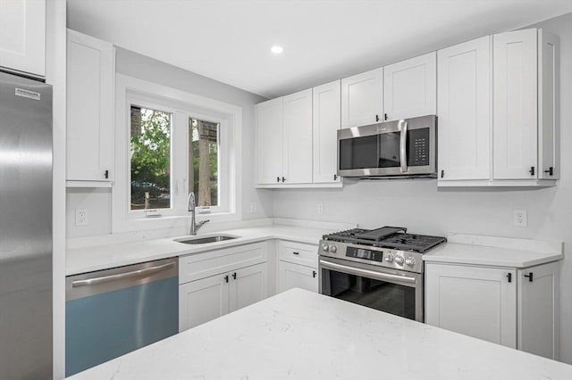 1514 Gorham St Unit 4, Lowell, MA 01852 - kitchen with appliances with stainless steel finishes, a sink, light stone counters, white cabinetry, and recessed lighting