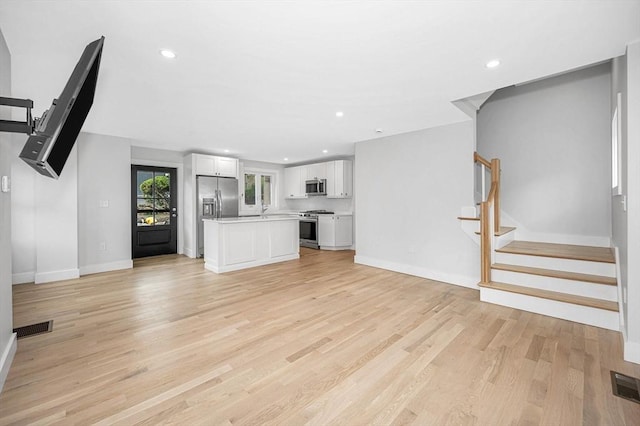 1514 Gorham St Unit 4, Lowell, MA 01852 - unfurnished living room with baseboards, light wood-style floors, stairs, and recessed lighting