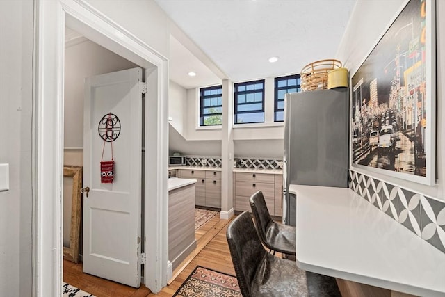 home office with light hardwood / wood-style flooring