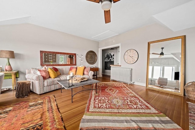 living room with ceiling fan, hardwood / wood-style flooring, radiator heating unit, and vaulted ceiling