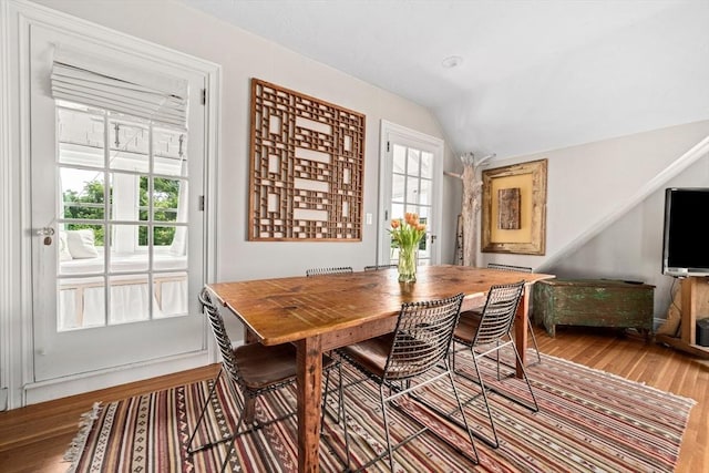 dining area featuring hardwood / wood-style floors and lofted ceiling