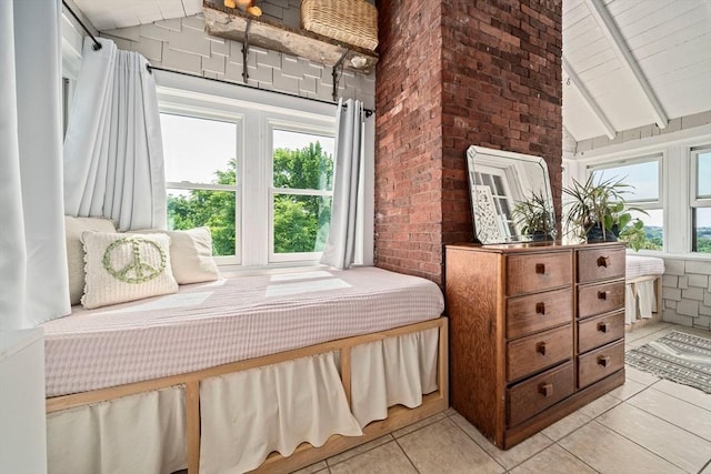 tiled bedroom with brick wall and lofted ceiling with beams