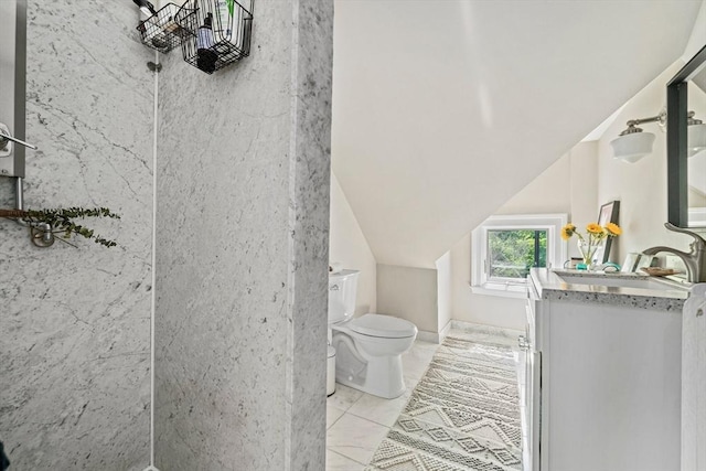 bathroom featuring toilet, vanity, and vaulted ceiling