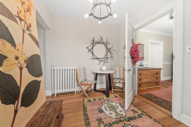 corridor featuring a chandelier, light hardwood / wood-style flooring, radiator, and ornamental molding