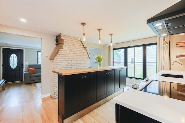 18 Carolina St, Medford, MA 02155 - kitchen featuring dark cabinets, butcher block countertops, a sink, light wood-style floors, and plenty of natural light