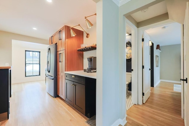 18 Carolina St, Medford, MA 02155 - kitchen featuring freestanding refrigerator, light wood-style flooring, baseboards, light countertops, and brown cabinets