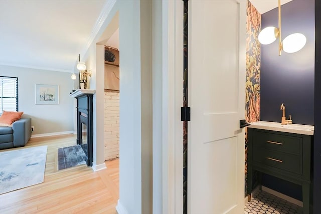 18 Carolina St, Medford, MA 02155 - bathroom with wood finished floors, ornamental molding, a glass covered fireplace, vanity, and baseboards
