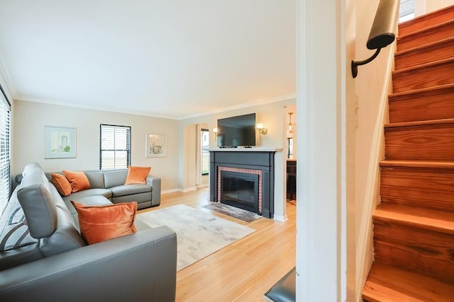 18 Carolina St, Medford, MA 02155 - living room with crown molding, light wood-type flooring, a fireplace, baseboards, and stairway