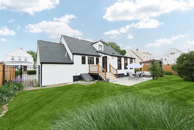 18 Carolina St, Medford, MA 02155 - back of property featuring a shingled roof, a patio area, and an outdoor living space