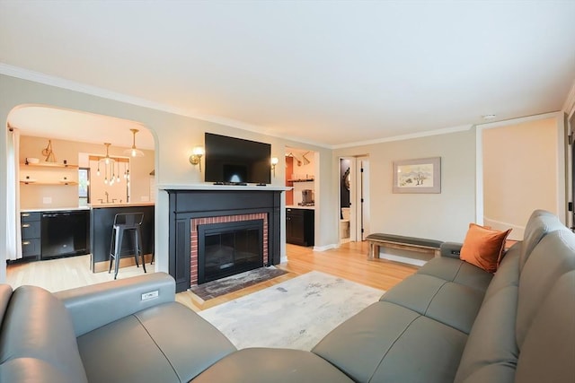18 Carolina St, Medford, MA 02155 - living area featuring light wood-style flooring, crown molding, a fireplace, arched walkways, and baseboards