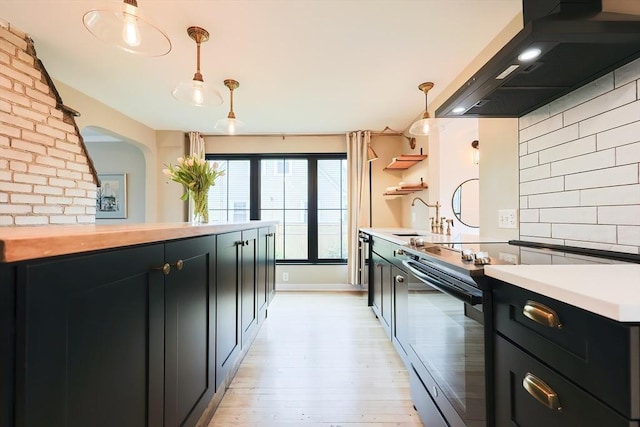 18 Carolina St, Medford, MA 02155 - kitchen with electric range oven, wall chimney exhaust hood, a sink, dark cabinets, and backsplash
