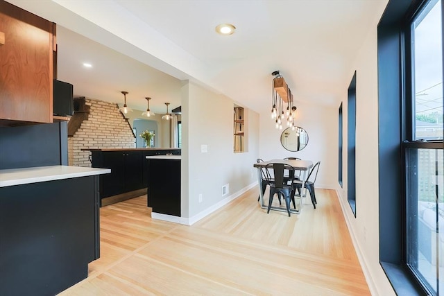 18 Carolina St, Medford, MA 02155 - kitchen with dark cabinetry, light wood-style flooring, decorative light fixtures, baseboards, and light countertops