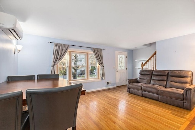 living room featuring an AC wall unit and hardwood / wood-style flooring