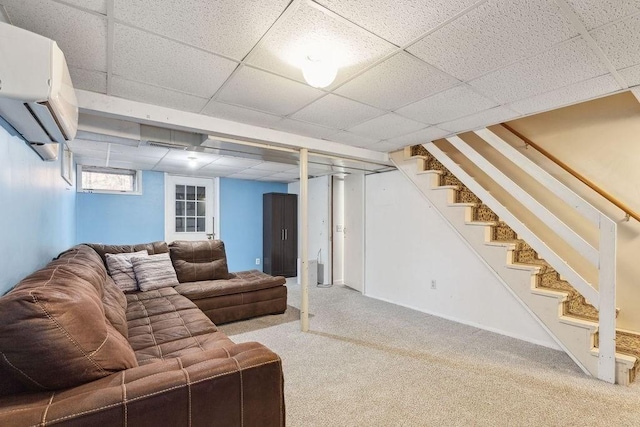 living room featuring carpet flooring, a wall unit AC, and a drop ceiling