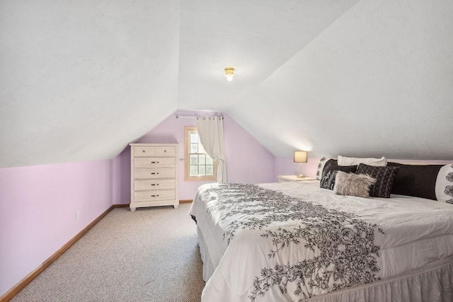 carpeted bedroom with lofted ceiling