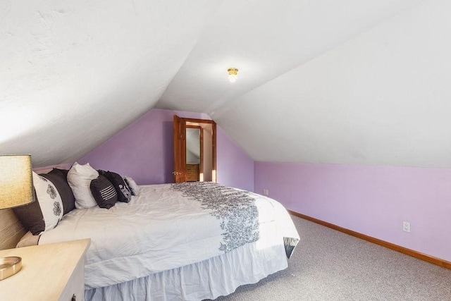 bedroom with carpet floors and vaulted ceiling