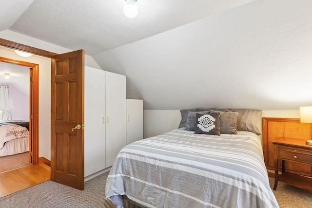 carpeted bedroom featuring lofted ceiling